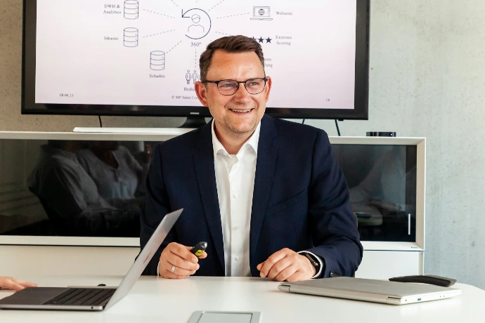 Man in suit smiling in a meeting room